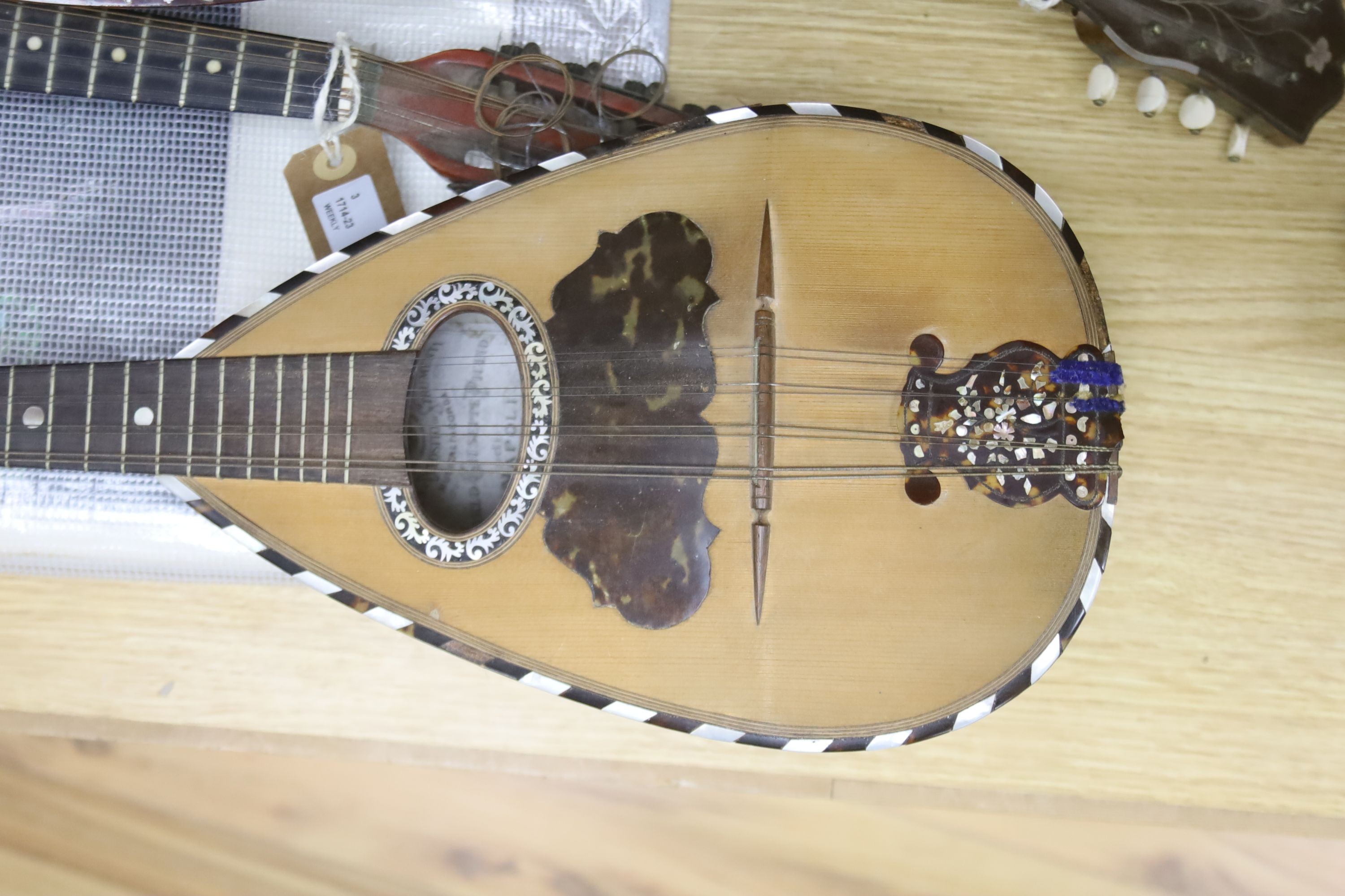 Three Neapolitan mandolins with inlaid mother of pearl decoration, one of round-backed form, the other two archtop